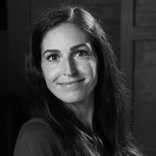 Woman with long hair smiles, looking at the camera.