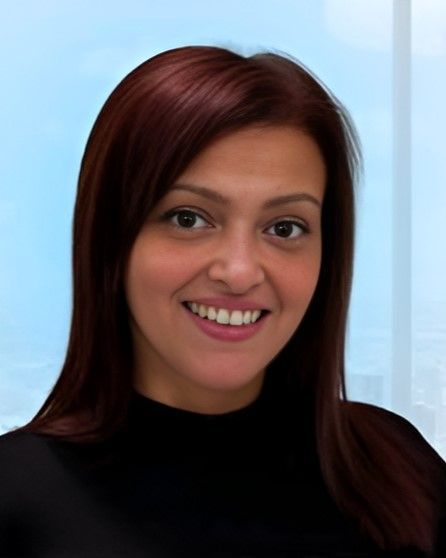 A smiling woman with colored hair wearing a black top.