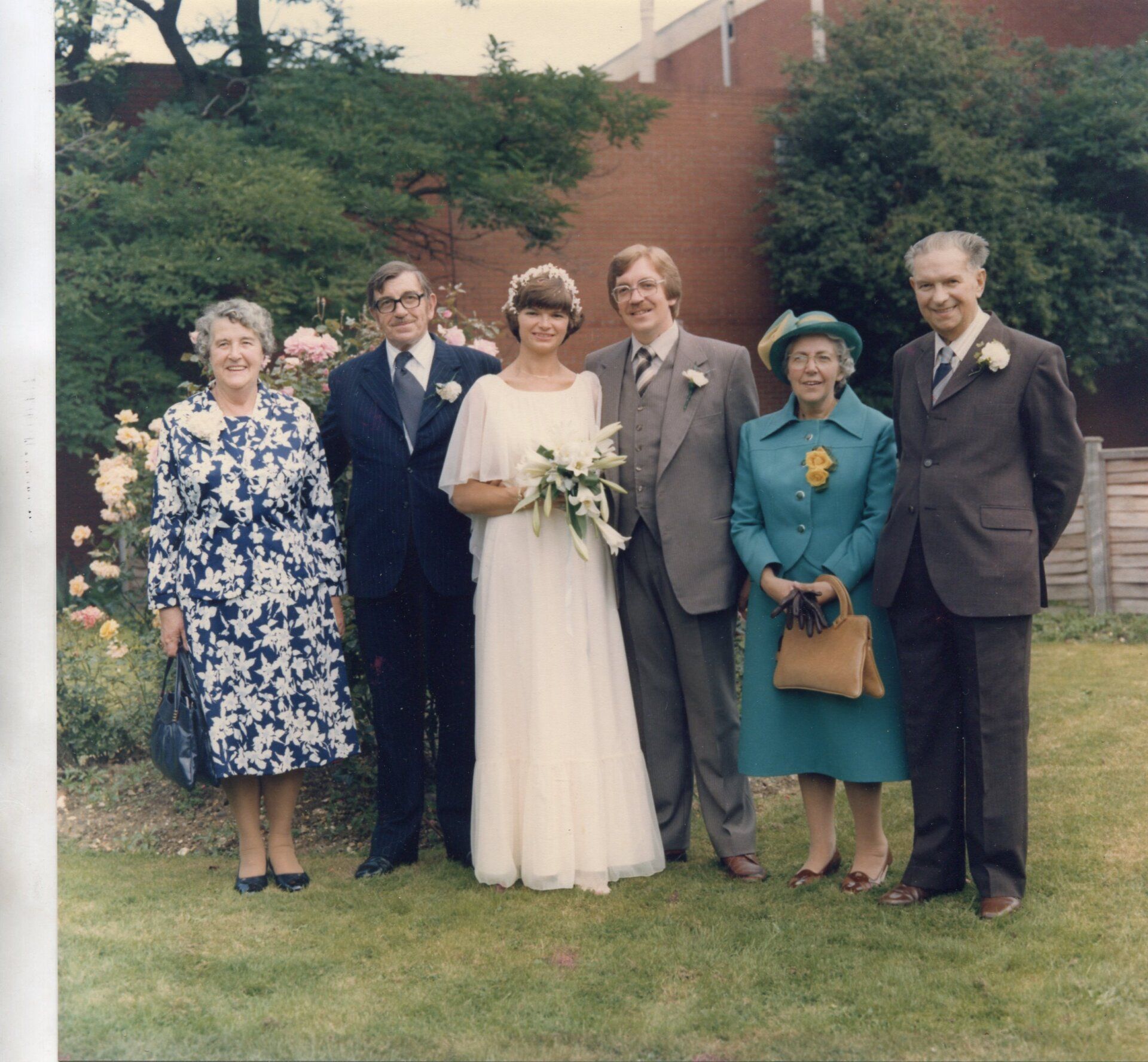 A group of people posing for a picture including a bride and groom