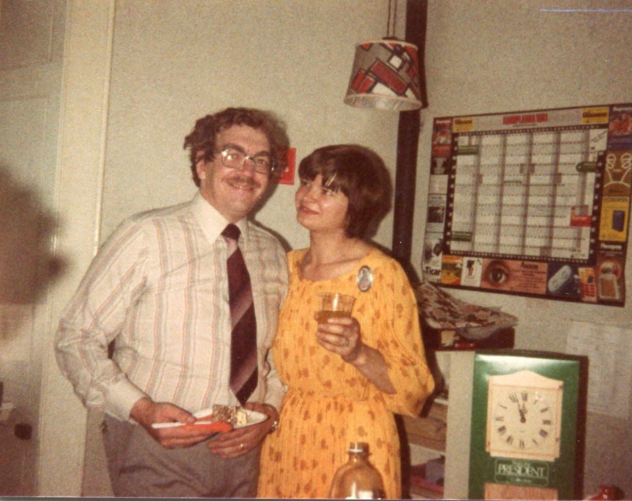 A man and a woman standing next to each other in front of a clock