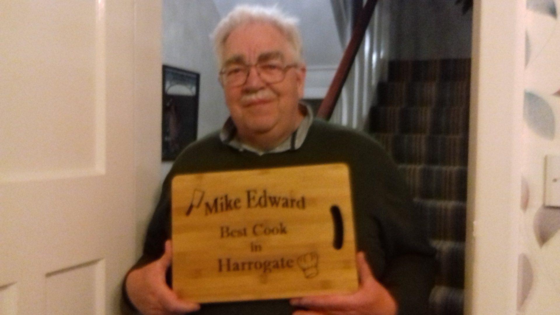 A man is holding a sign that says mike edward