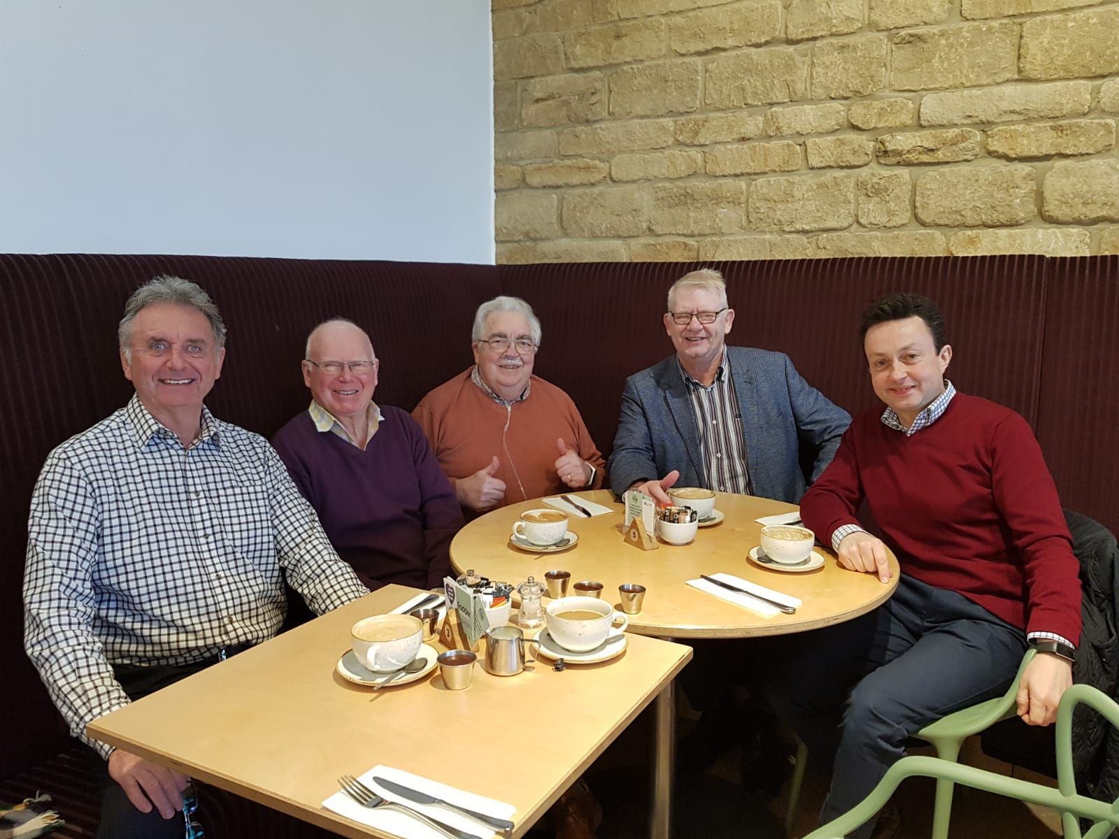 A group of men are sitting at a table in a restaurant.