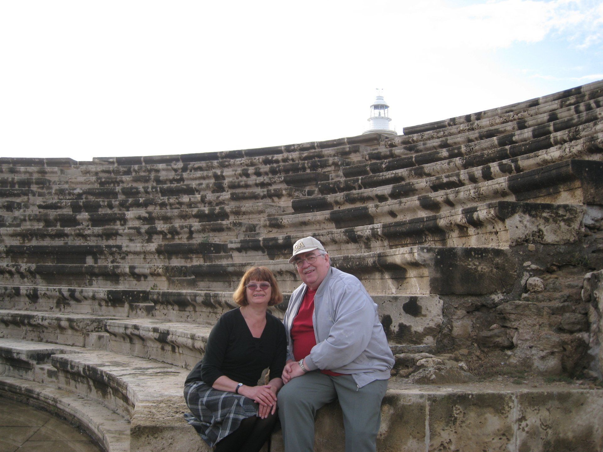 A man and a woman are posing for a picture in an amphitheater.
