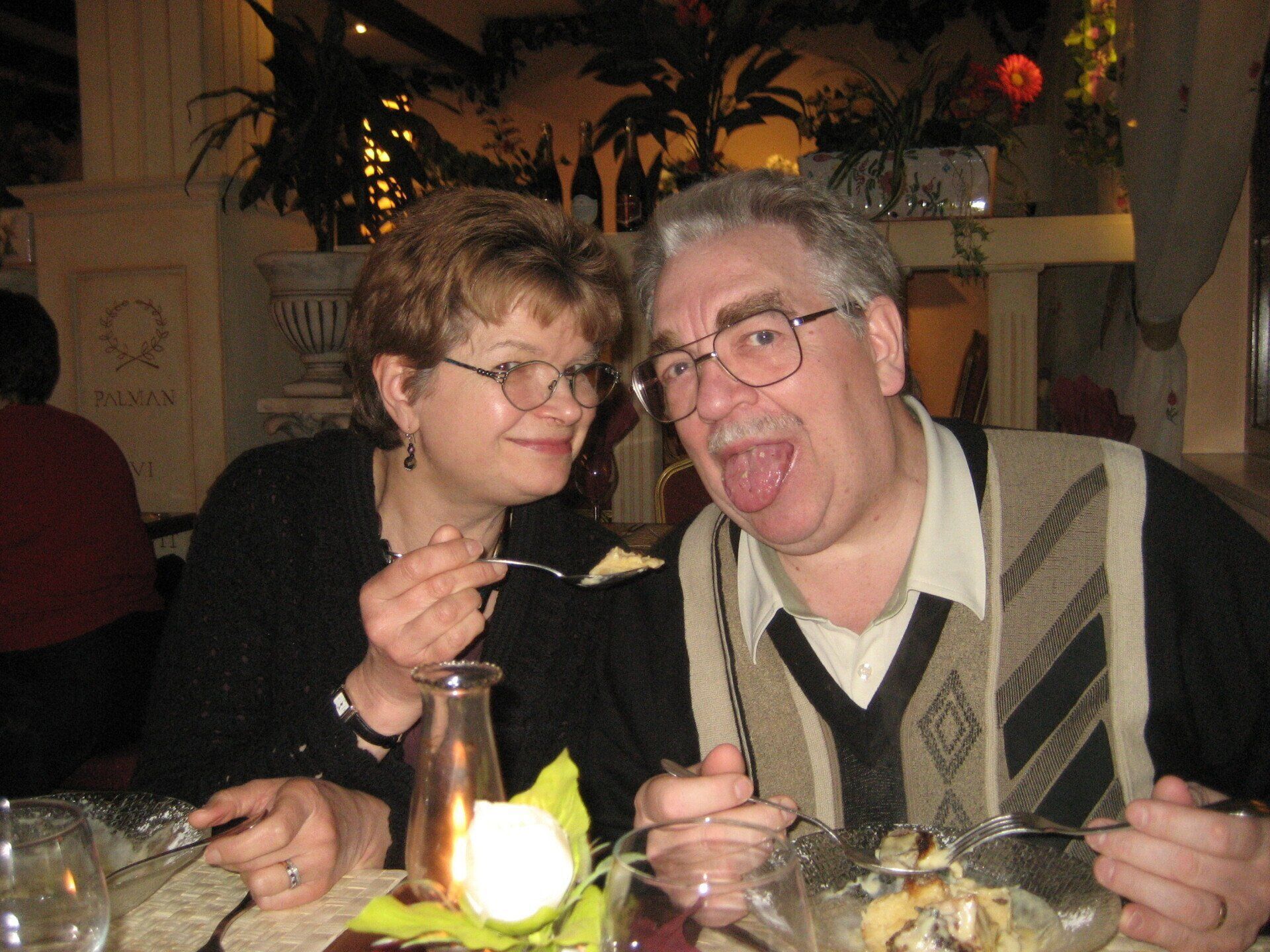 A man and a woman are sitting at a table eating food