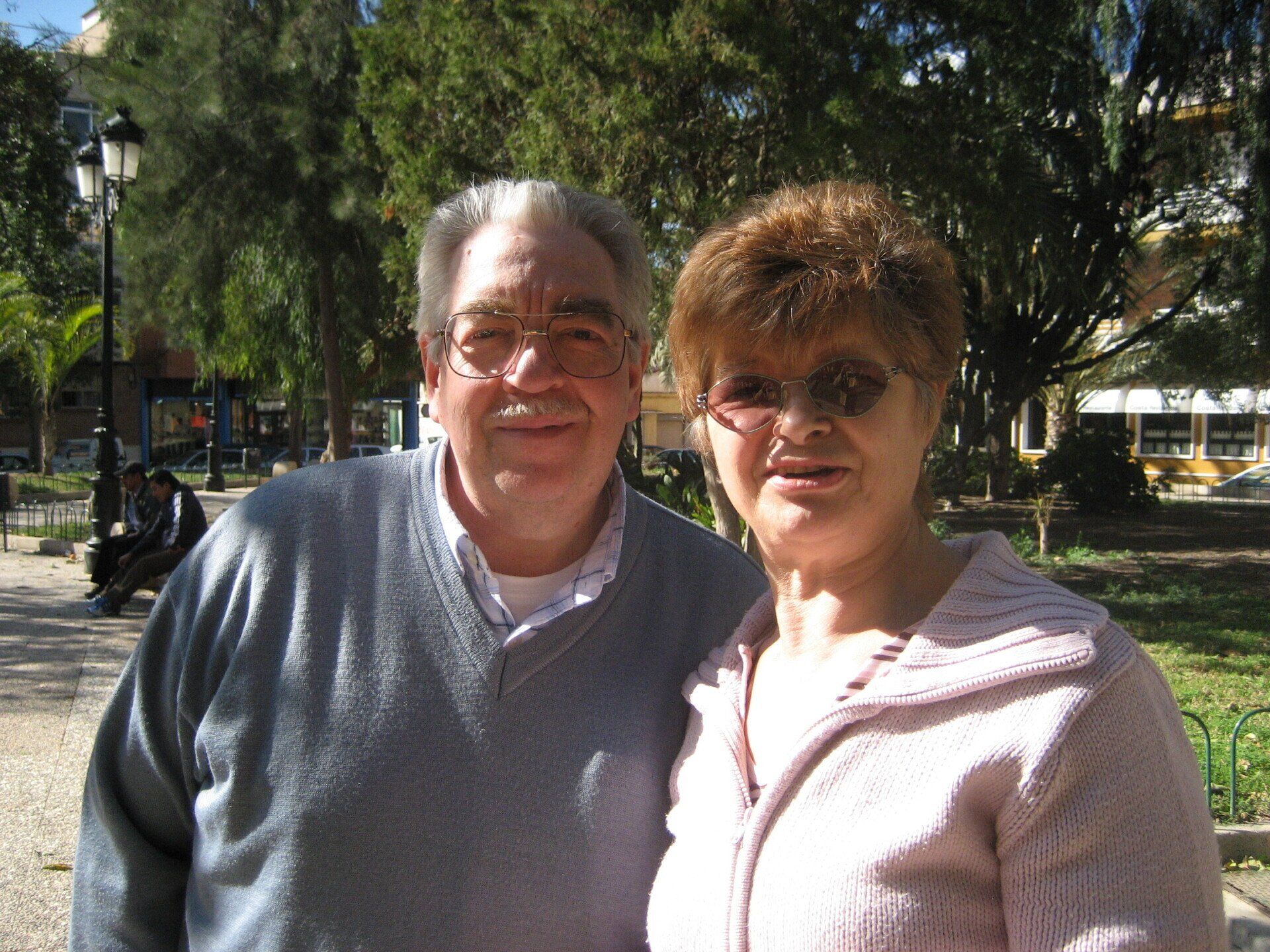 A man and a woman posing for a picture in a park