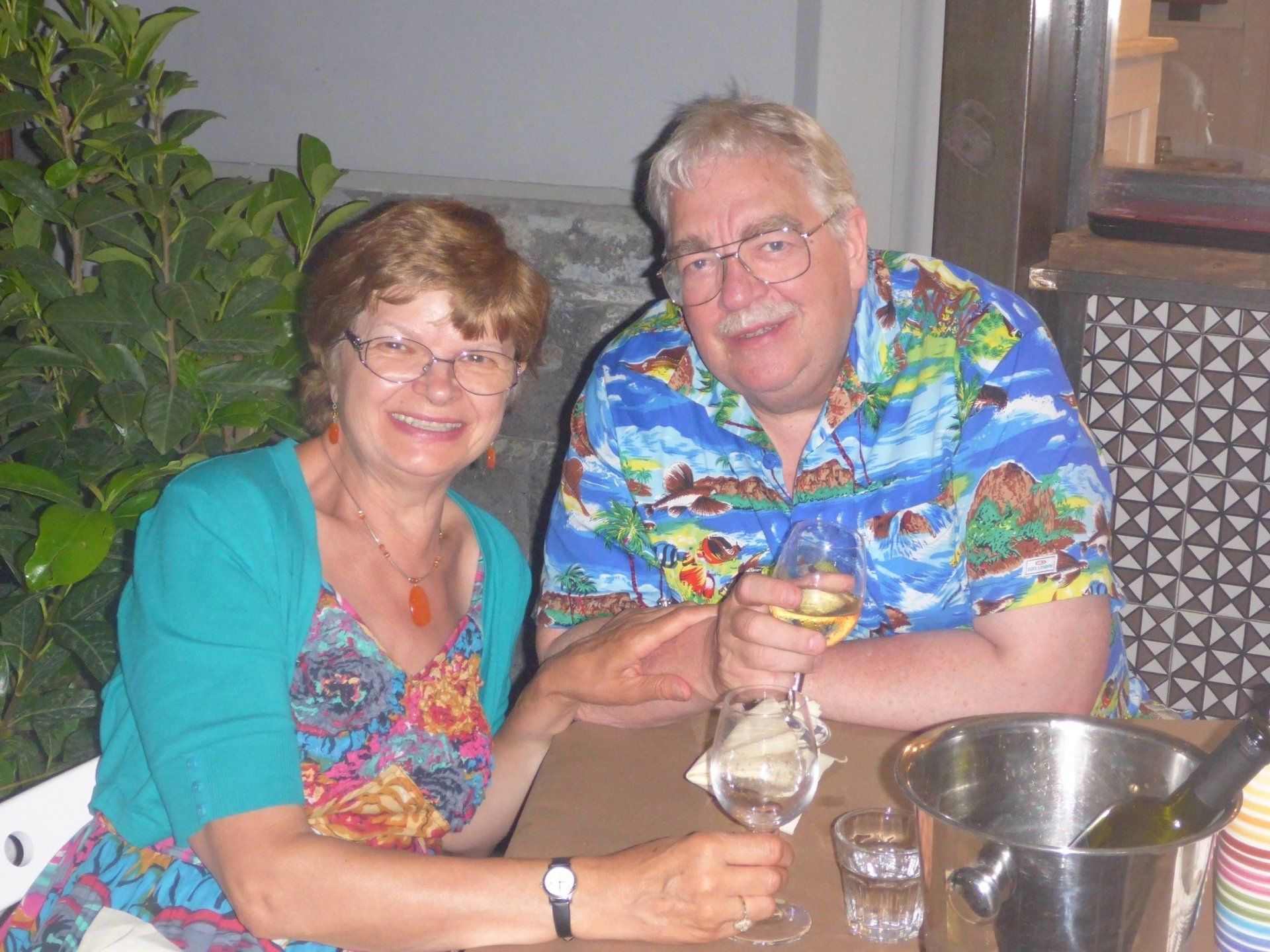 A man and a woman are sitting at a table drinking wine