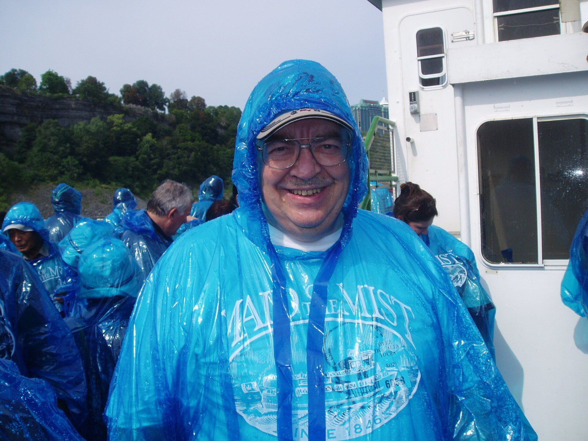 A man wearing a blue poncho with the word miss on it