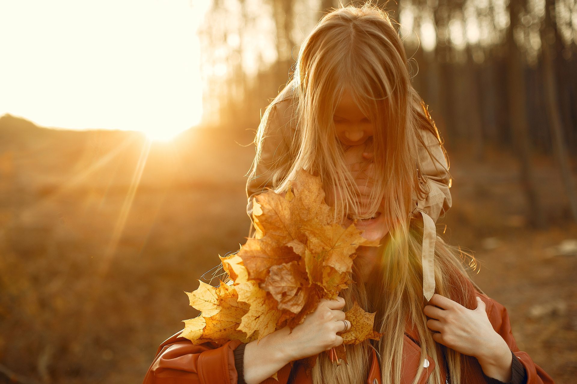 una mujer con el pelo rizado sostiene una flor en la cabeza y sonríe .