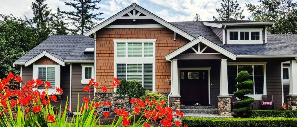 House with red flowers in garden | Vickery Properties