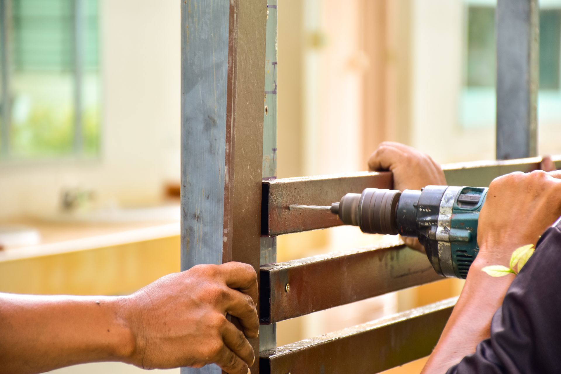 a man is using a drill to drill a hole in a piece of wood .