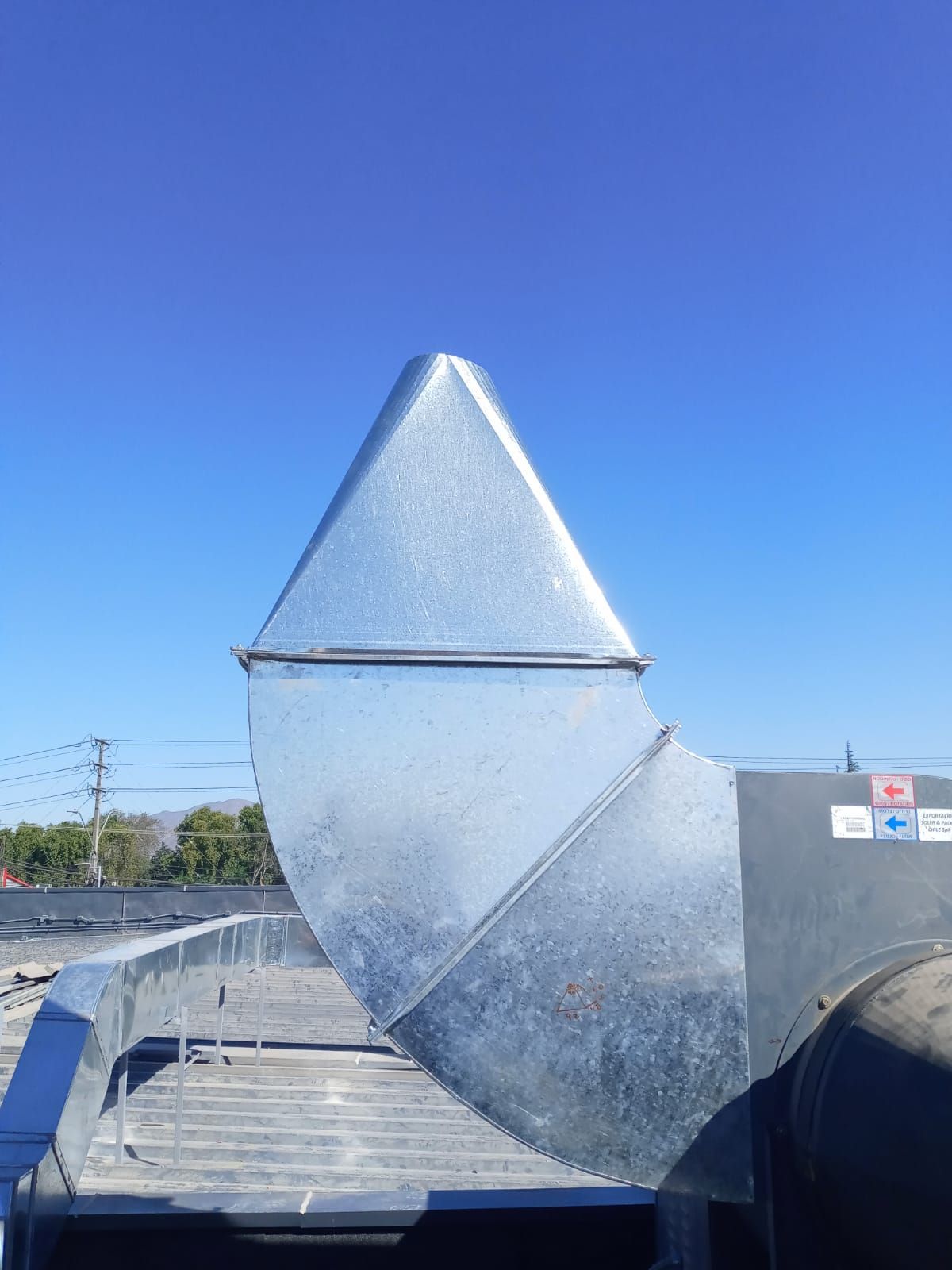 Un gran tubo de metal está colocado encima de un techo.