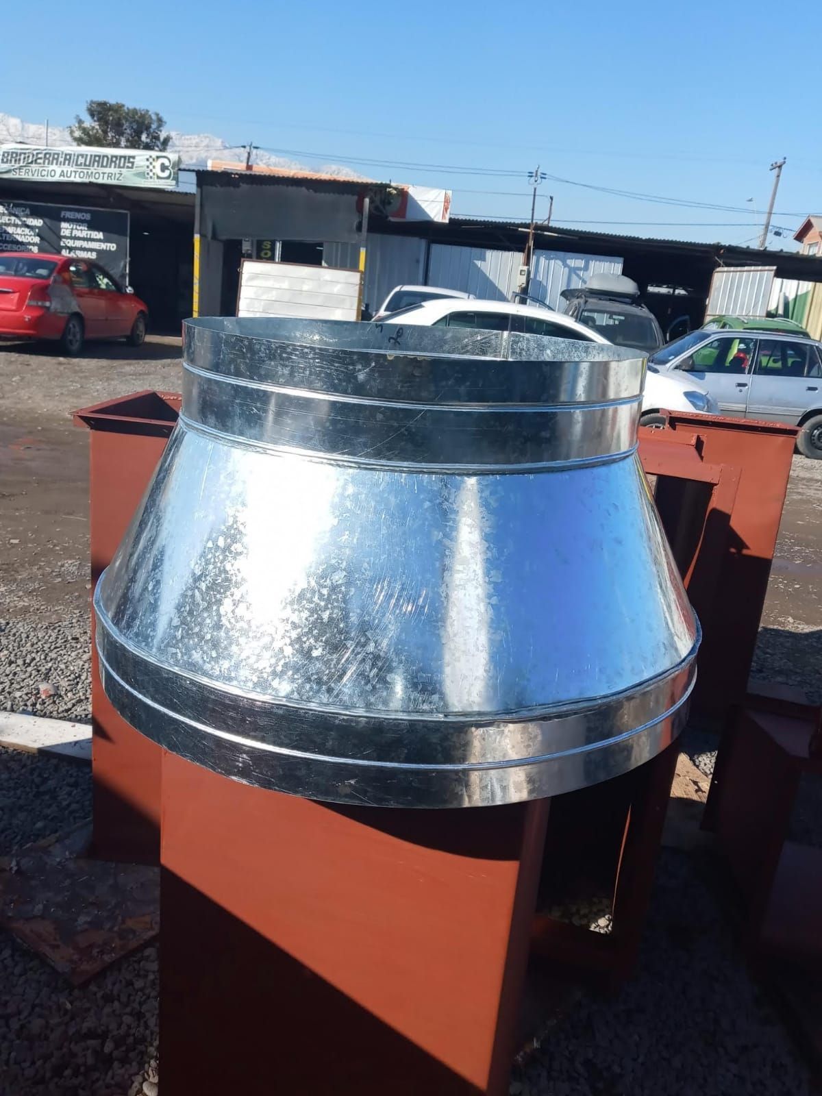 Un cono de metal está encima de una caja marrón.