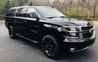 A black suv is parked in a parking lot.