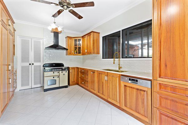 A kitchen with wooden cabinets and a ceiling fan