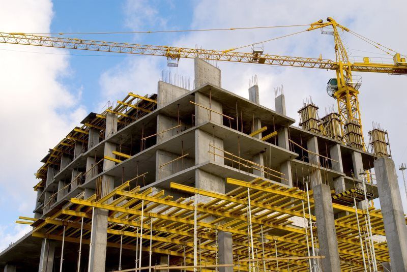 A large building is being built with a crane in the background.