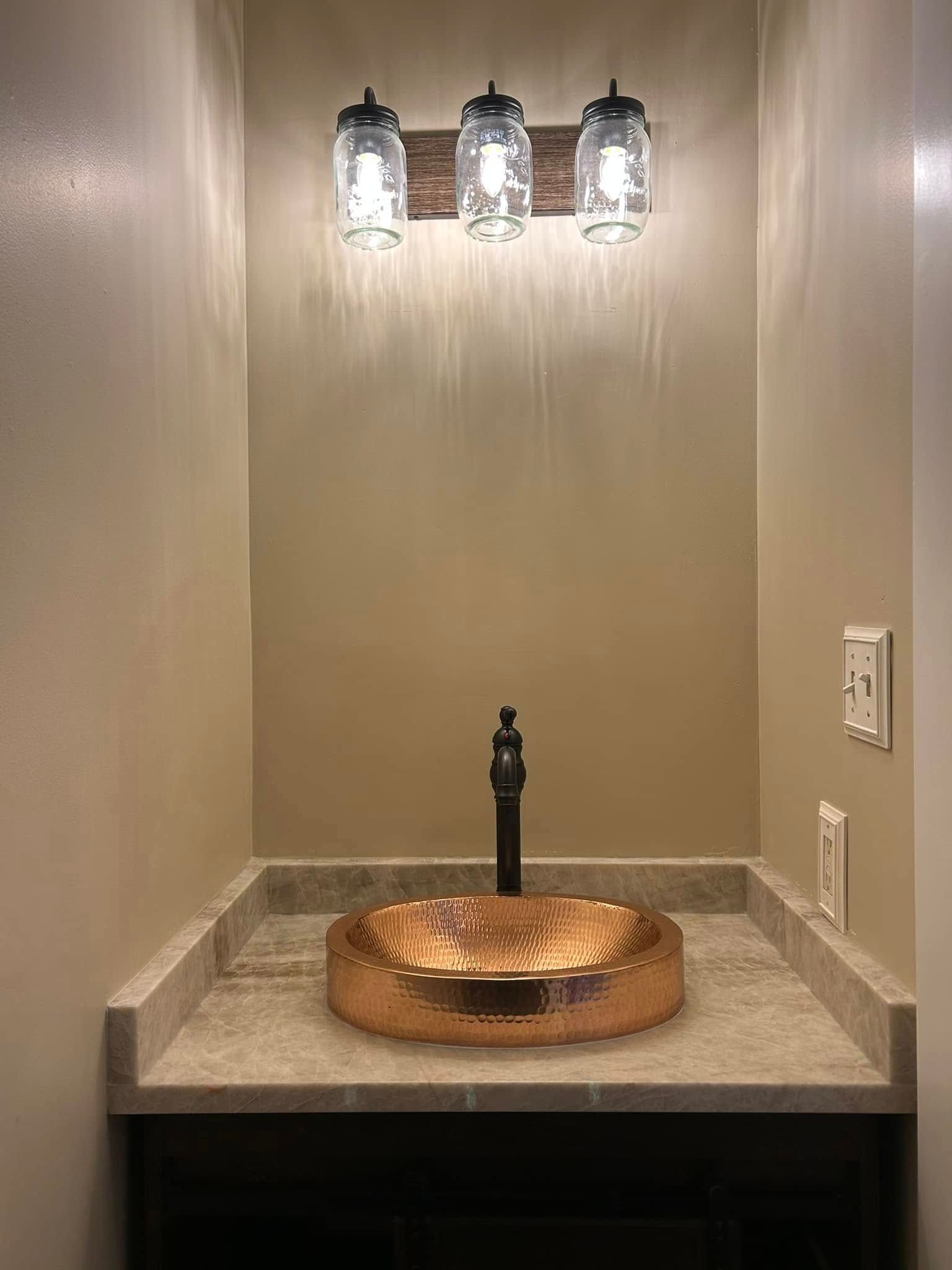 Copper sink and faucet, tan walls, rustic mason jar lights.