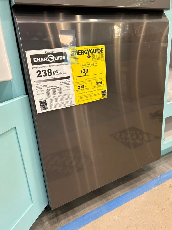Stainless steel dishwasher with energy guide stickers, flanked by light blue cabinetry.