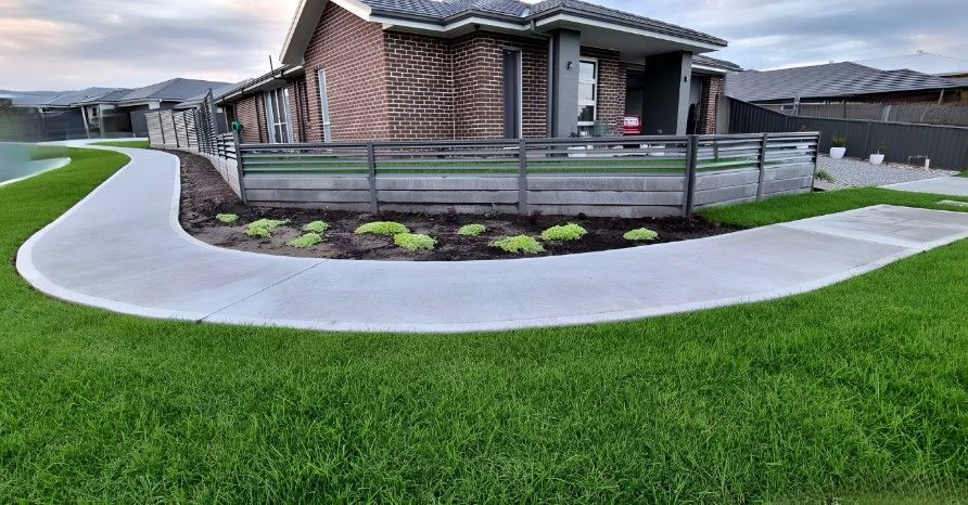 A House With a Concrete Walkway Leading to It and a Lawn — Superior Turf in Oak Flats, NSW