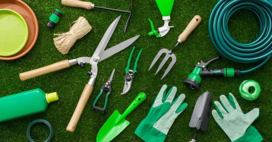 A Bunch of Gardening Tools Are Laying on the Grass — Superior Turf in Illawarra, NSW
