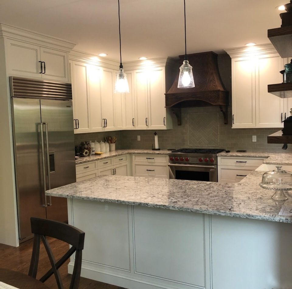 A kitchen with white cabinets and granite counter tops