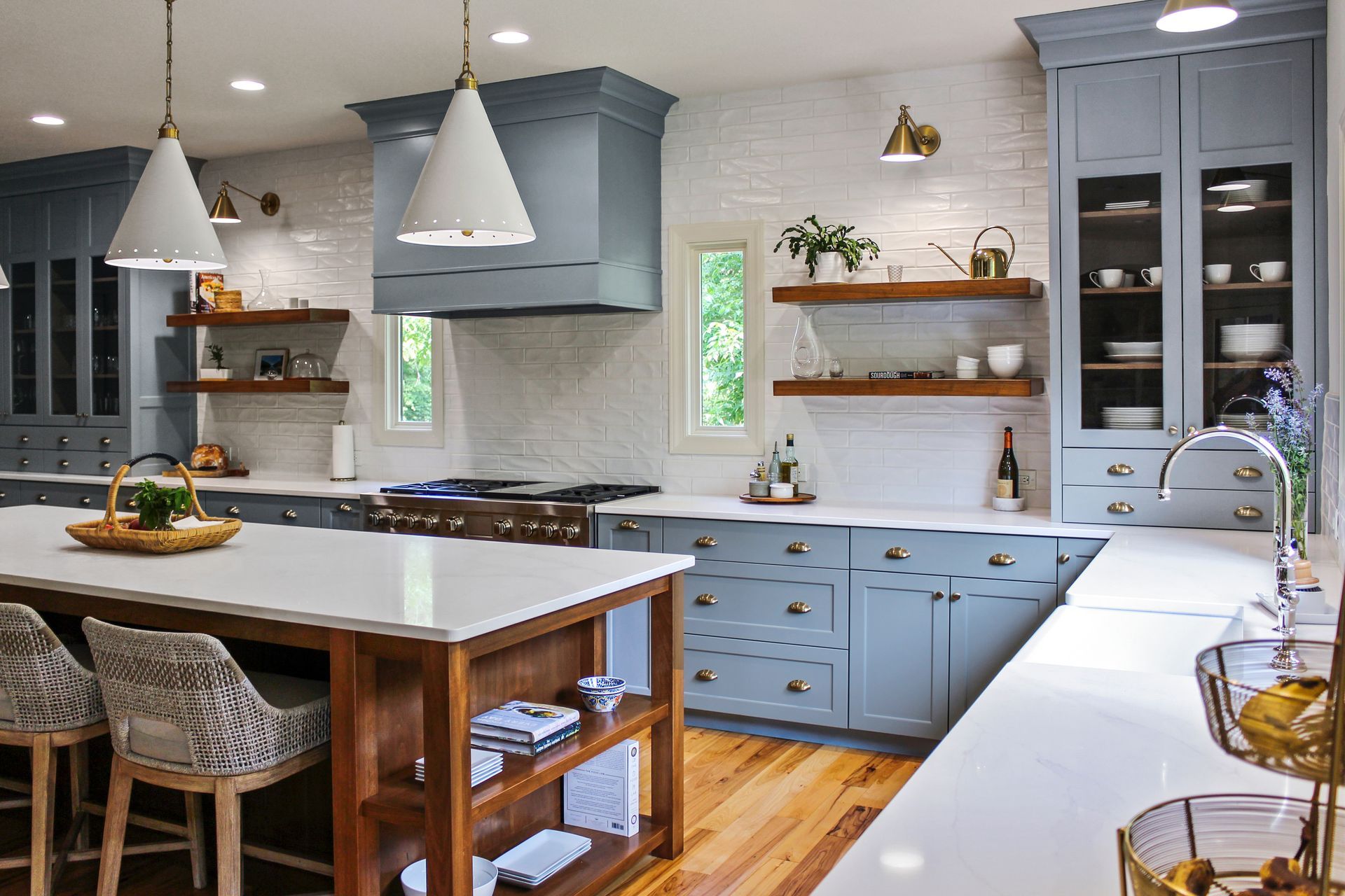 A kitchen with blue cabinets , white counter tops , and a large island.
