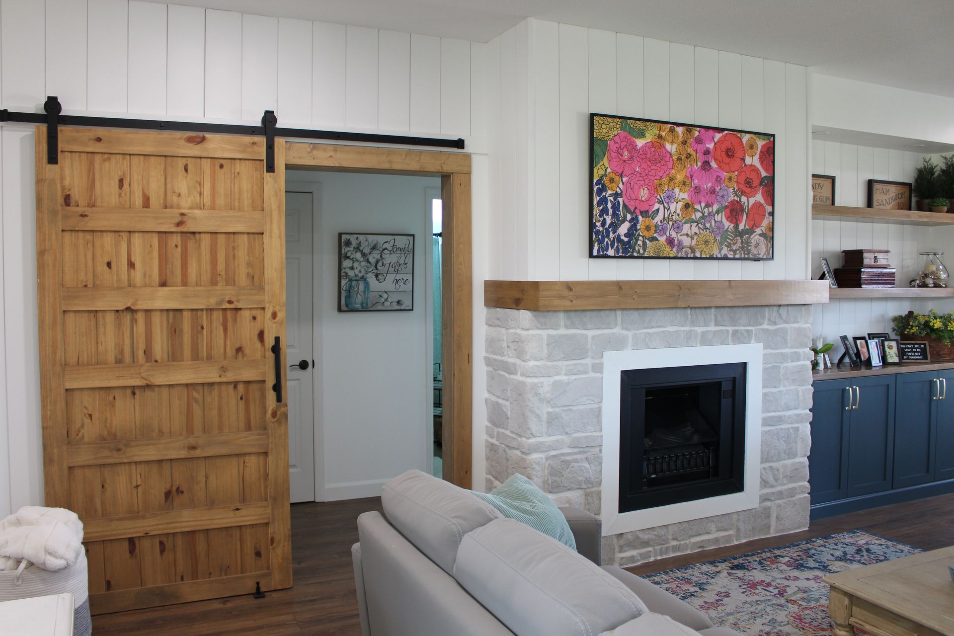 A living room with a sliding barn door and a fireplace.
