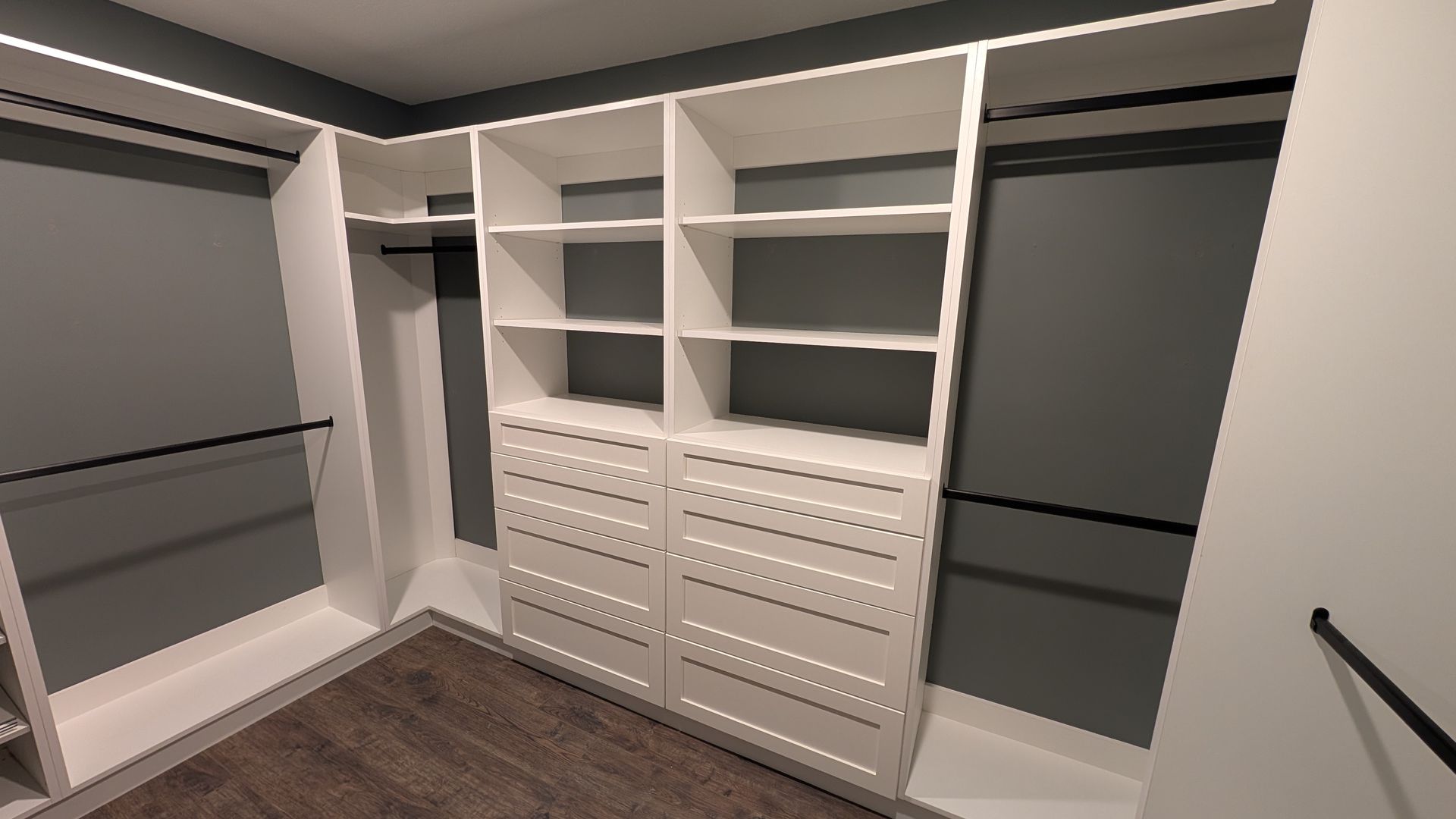 A walk in closet with lots of shelves and drawers