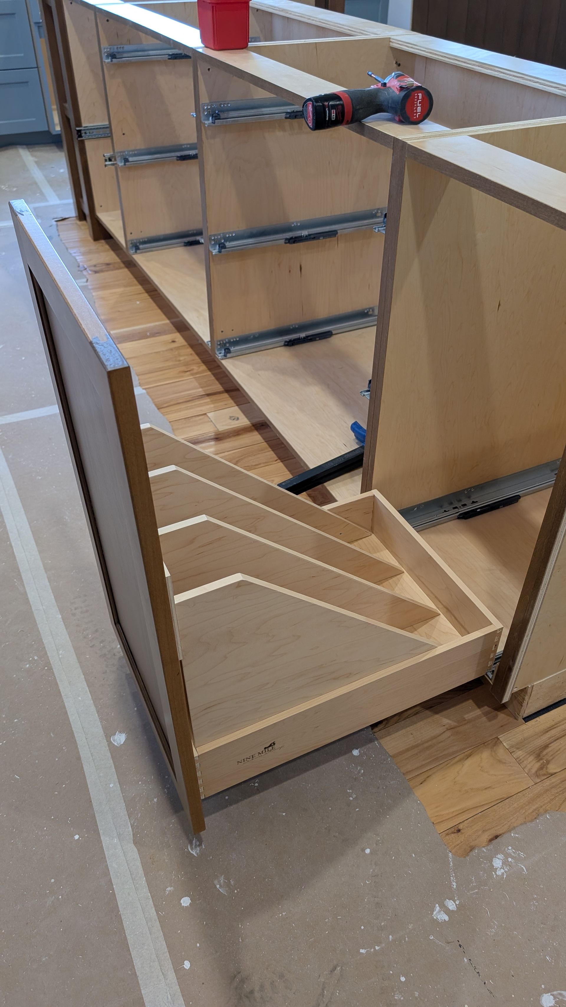 A wooden drawer with a screwdriver in it is being built.