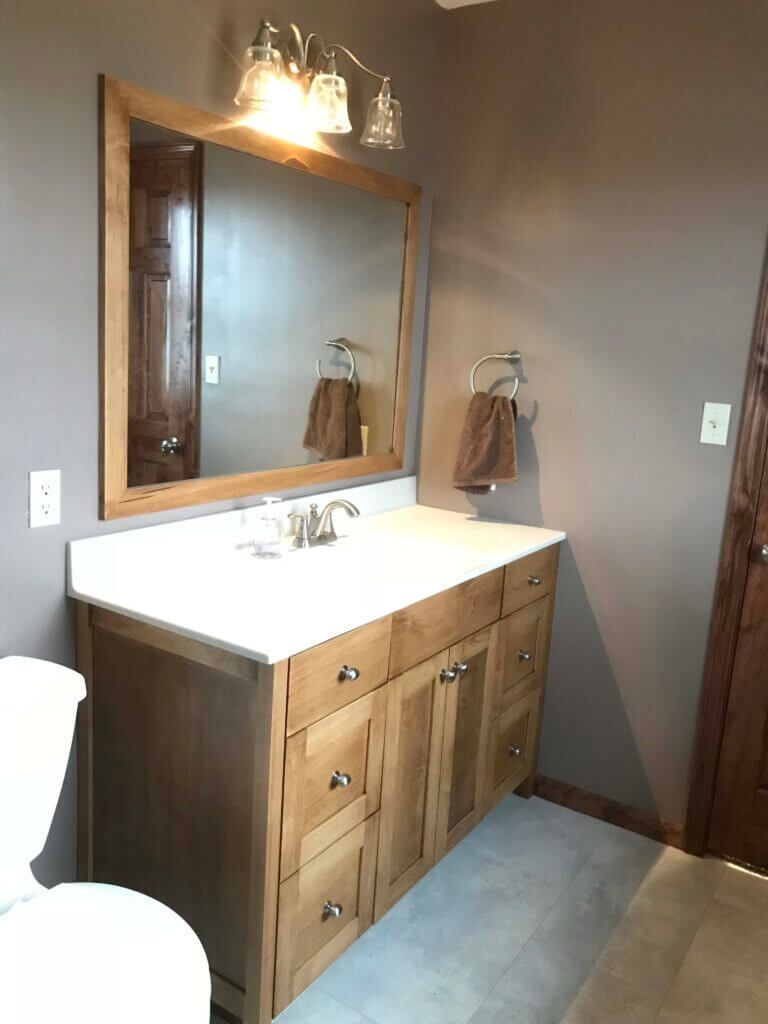 A bathroom with a sink , toilet and mirror.