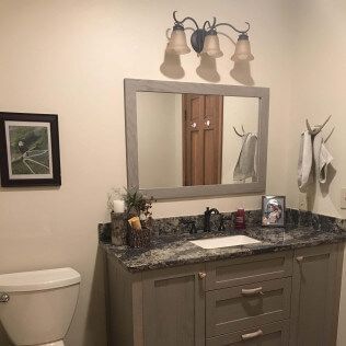 A bathroom with a sink , toilet and mirror.