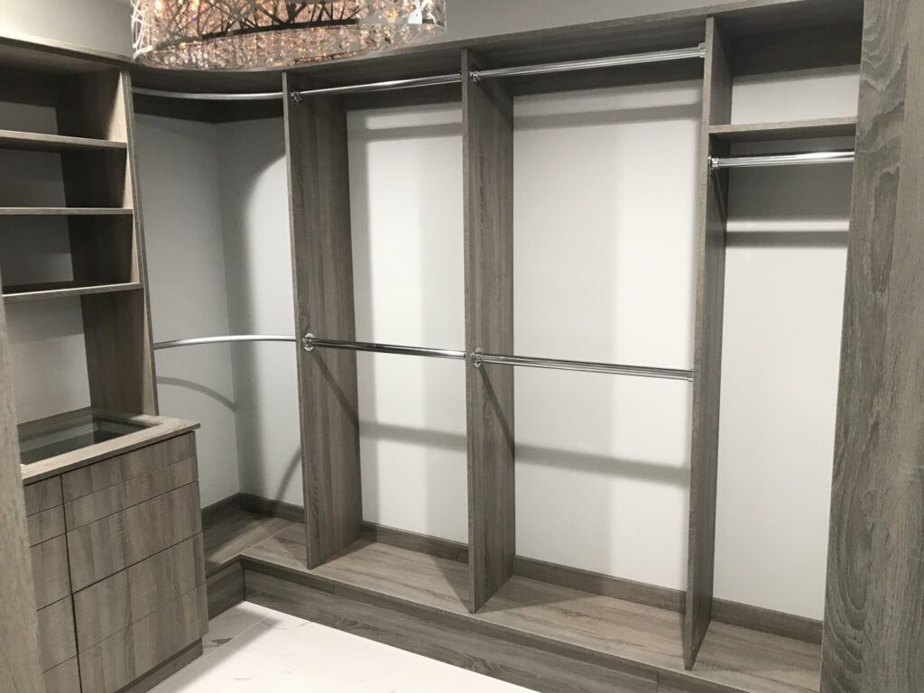 A walk in closet with lots of shelves and clothes racks.