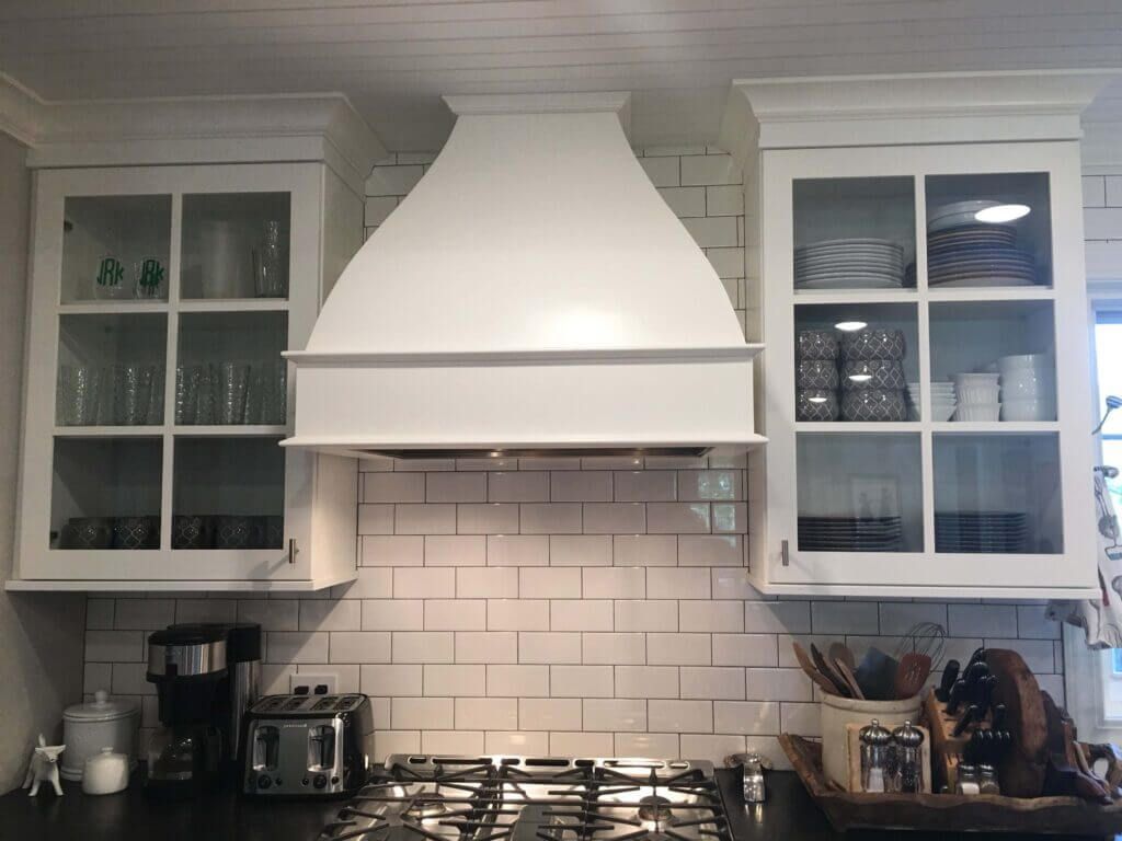 A kitchen with white cabinets and a stove top oven