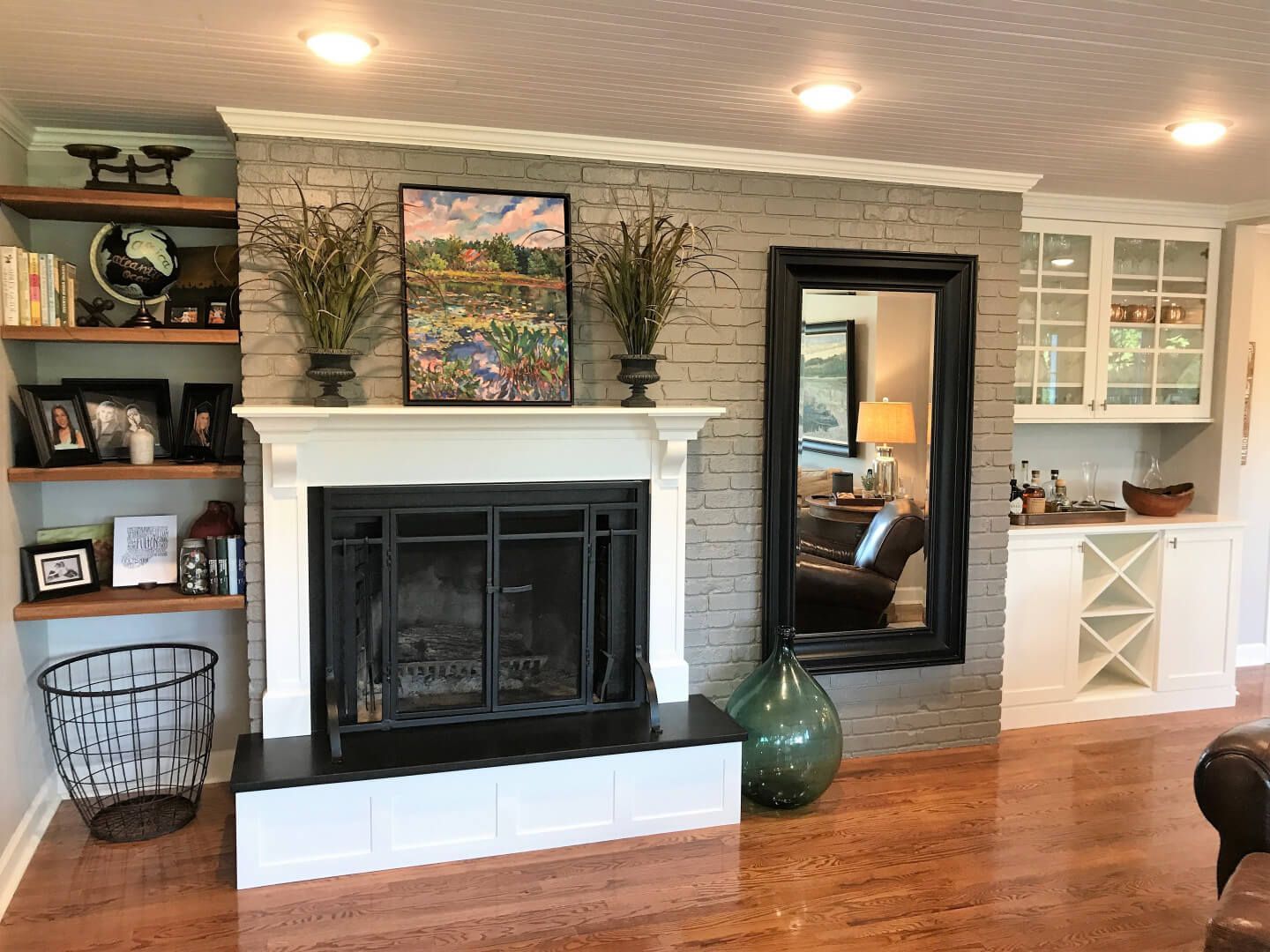 A living room with a fireplace and a mirror