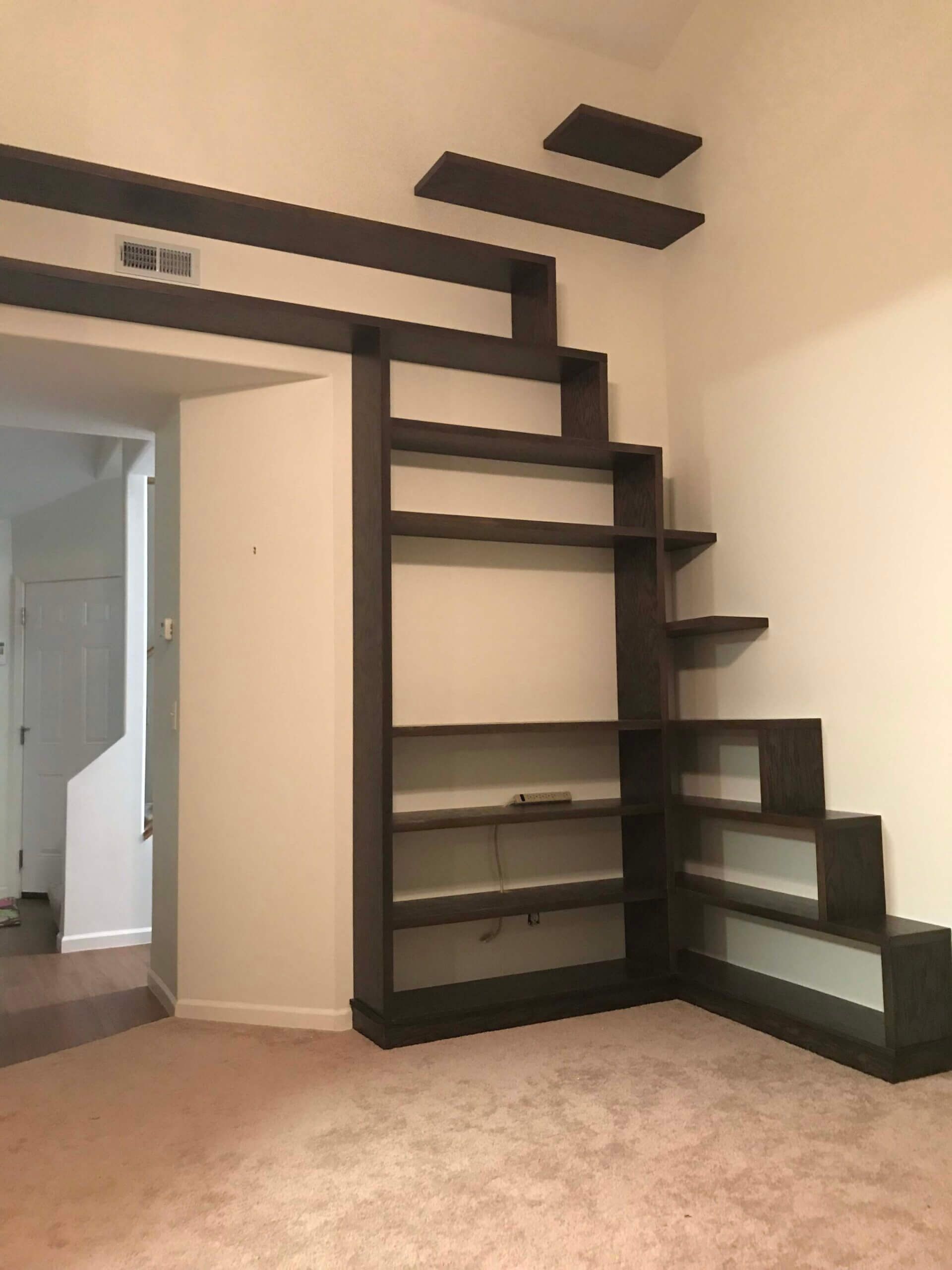 An empty room with shelves and stairs in it