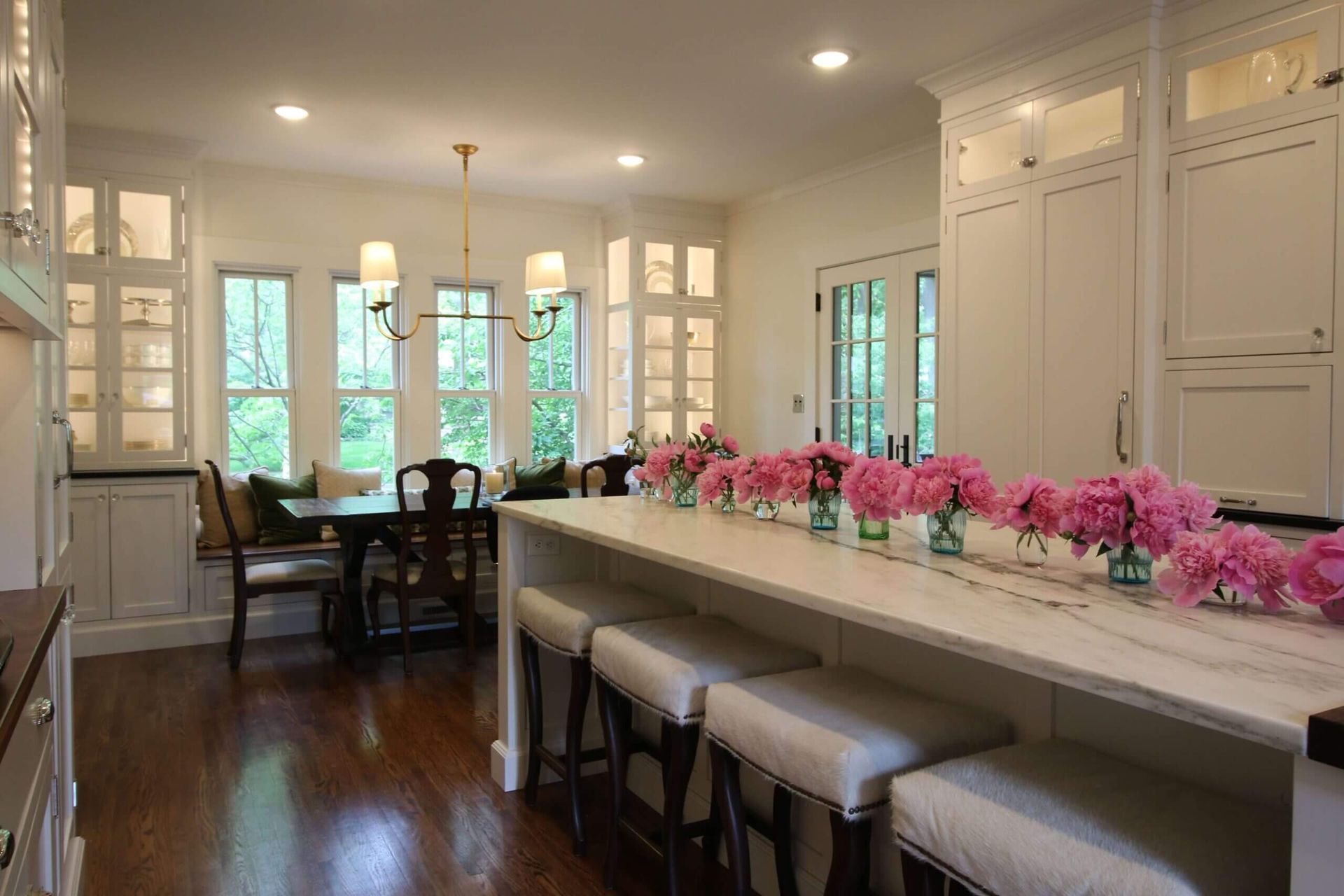 A kitchen with blue cabinets , a white sink , and a large window.