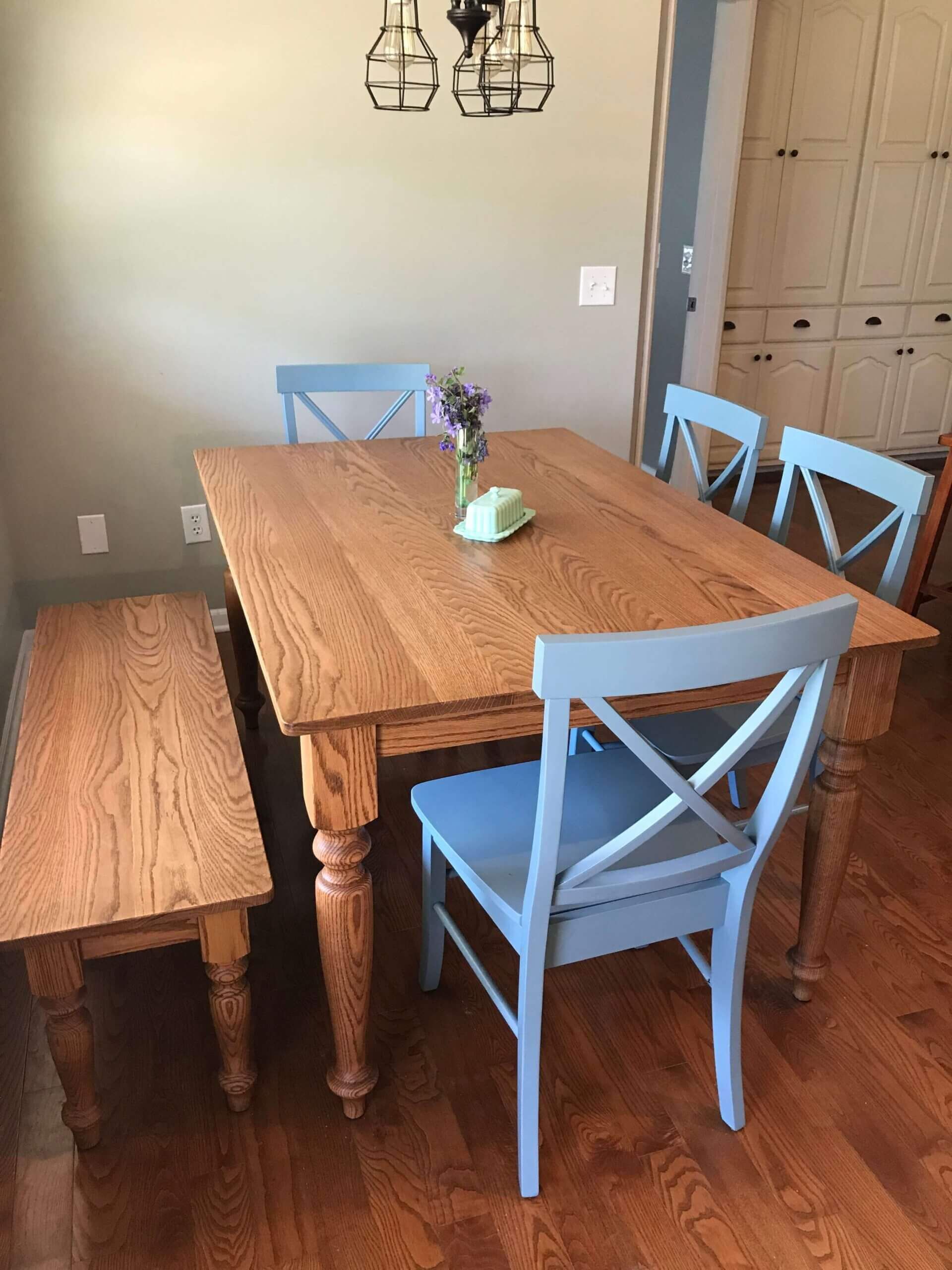 A wooden table with blue chairs and a bench