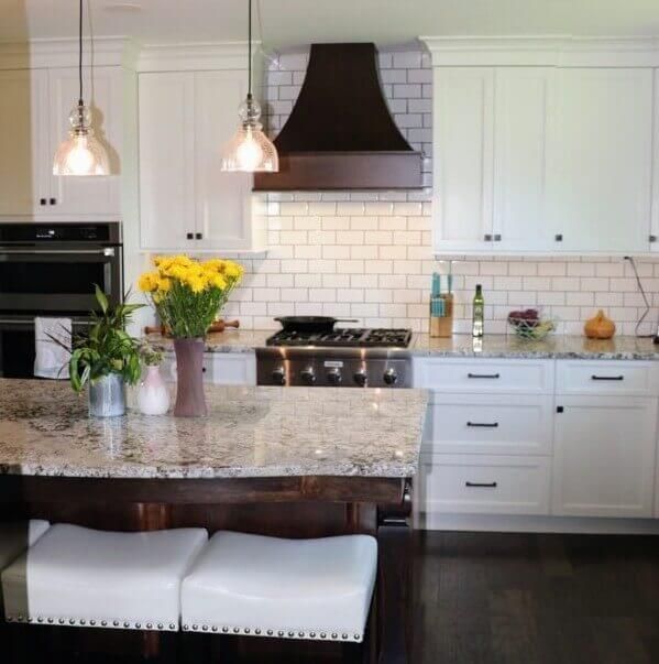 A kitchen with white cabinets and granite counter tops