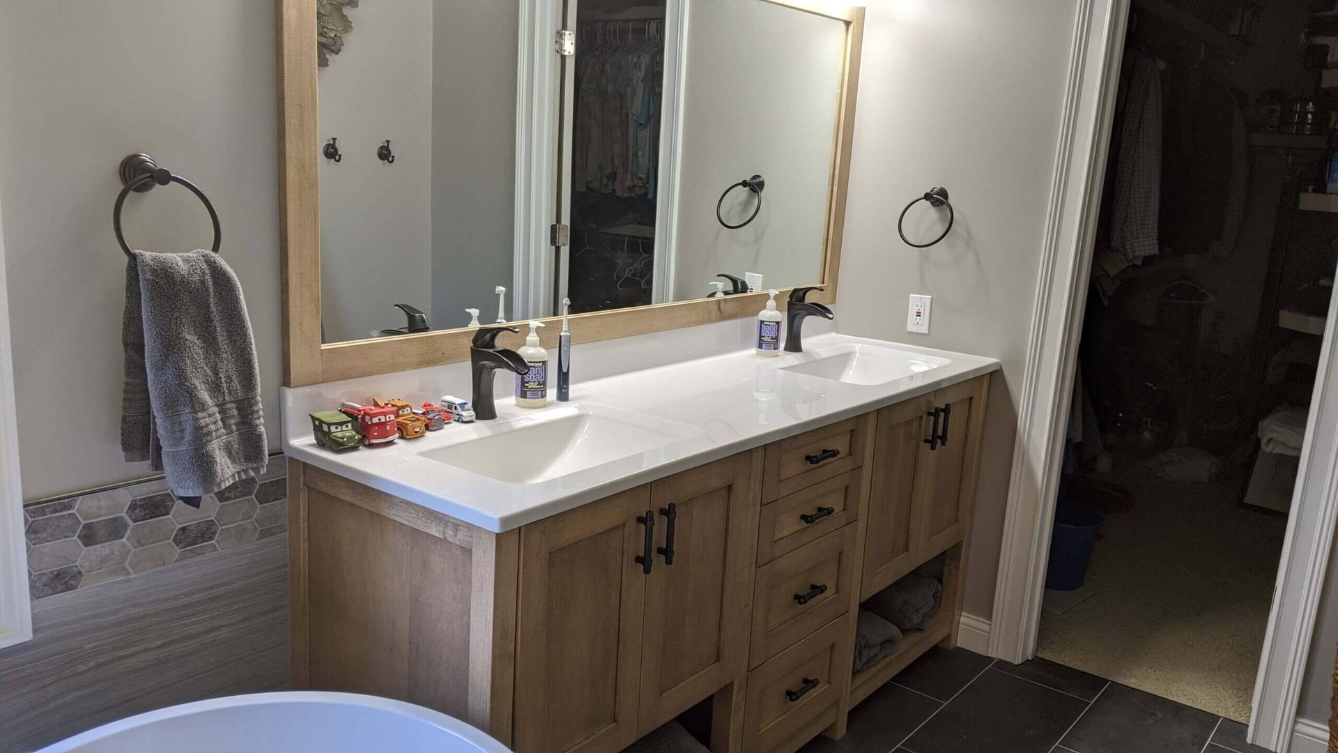 A bathroom with two sinks , two mirrors and a tub.
