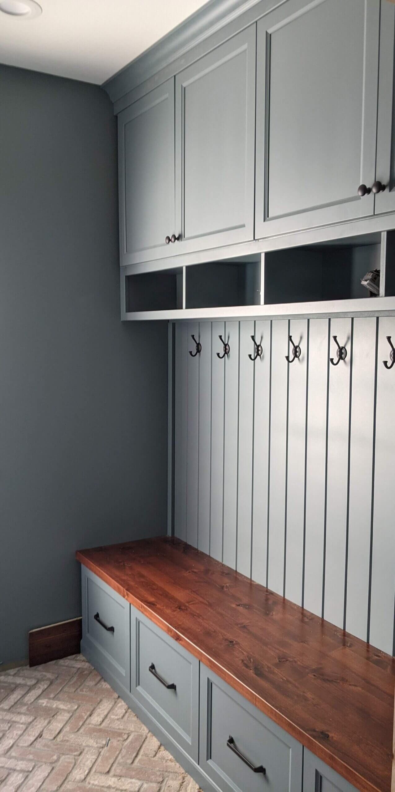 A mud room with a bench and hooks on the wall.