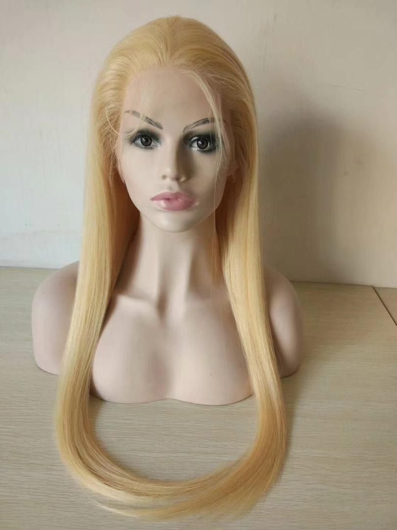Blonde wig on a mannequin head, straight long hair, pale skin, light background.