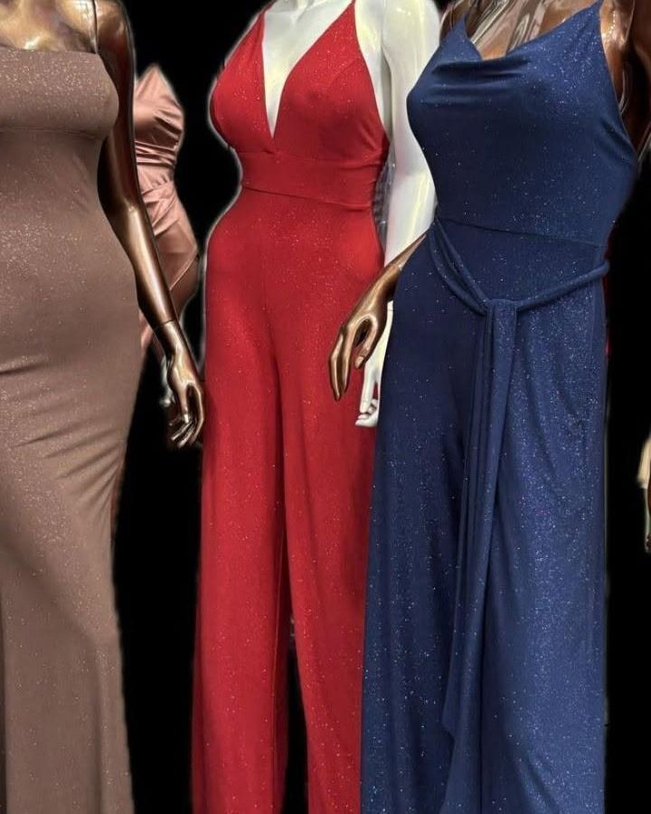Three mannequins in sparkly formal wear: brown gown, red jumpsuit, and blue jumpsuit.
