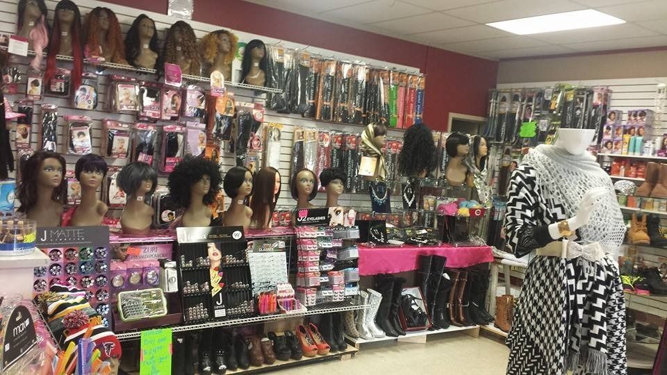 Hair store interior with wigs, extensions, and accessories displayed on shelves and mannequins.
