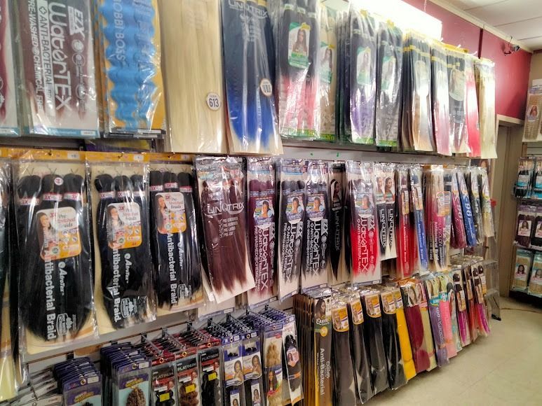 Shelf stocked with various hair extension bundles in a beauty supply store.