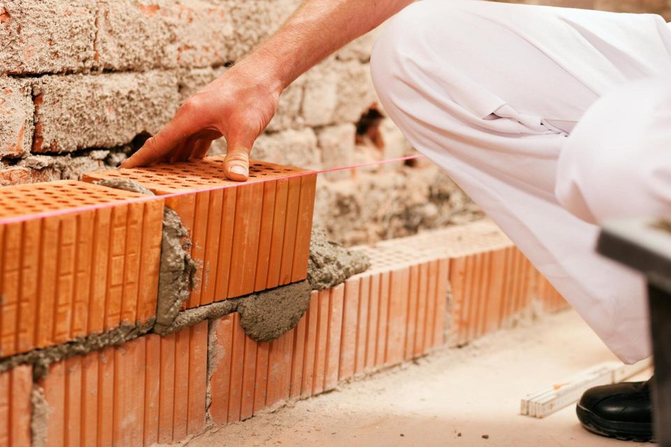 worker installing concrete bricks