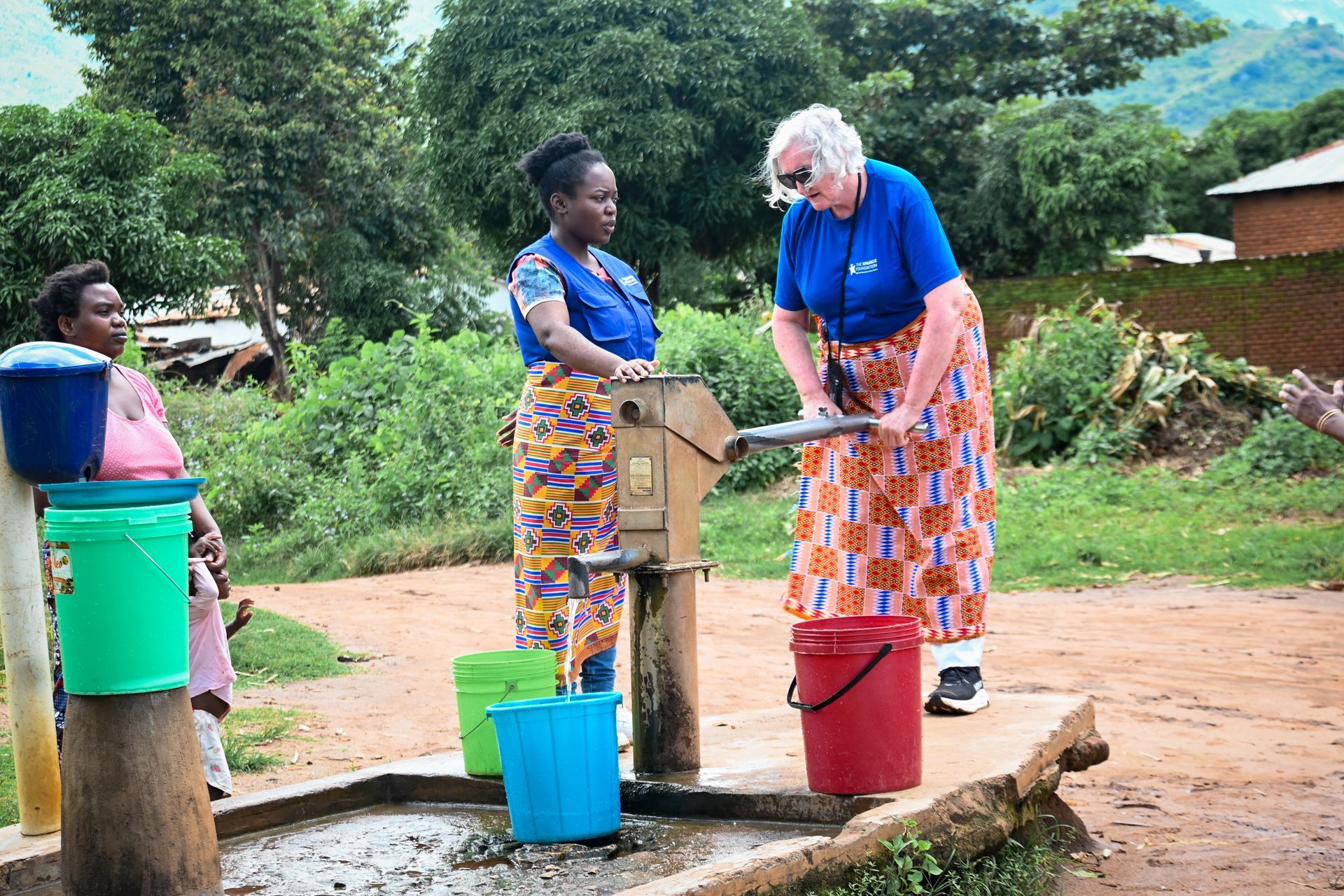Volunteer Leith with a local woman at a community water pump in Malawi,
during her Journey with Pur