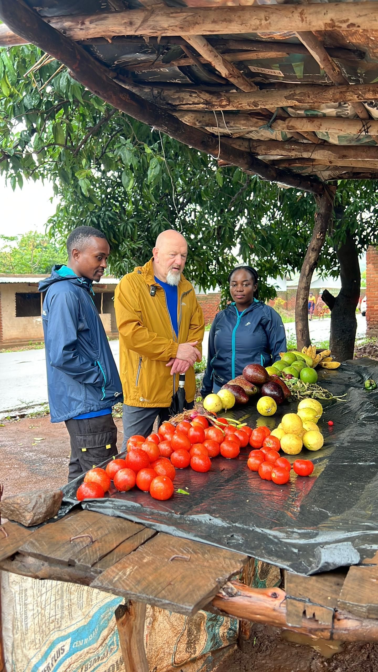 Stuart (the sparkle foundation volunteer) interacting with a woman produce vendor in the village of Sogoja in Malawi. the woman is a beneficiary of the sparkle foundation's women's programme