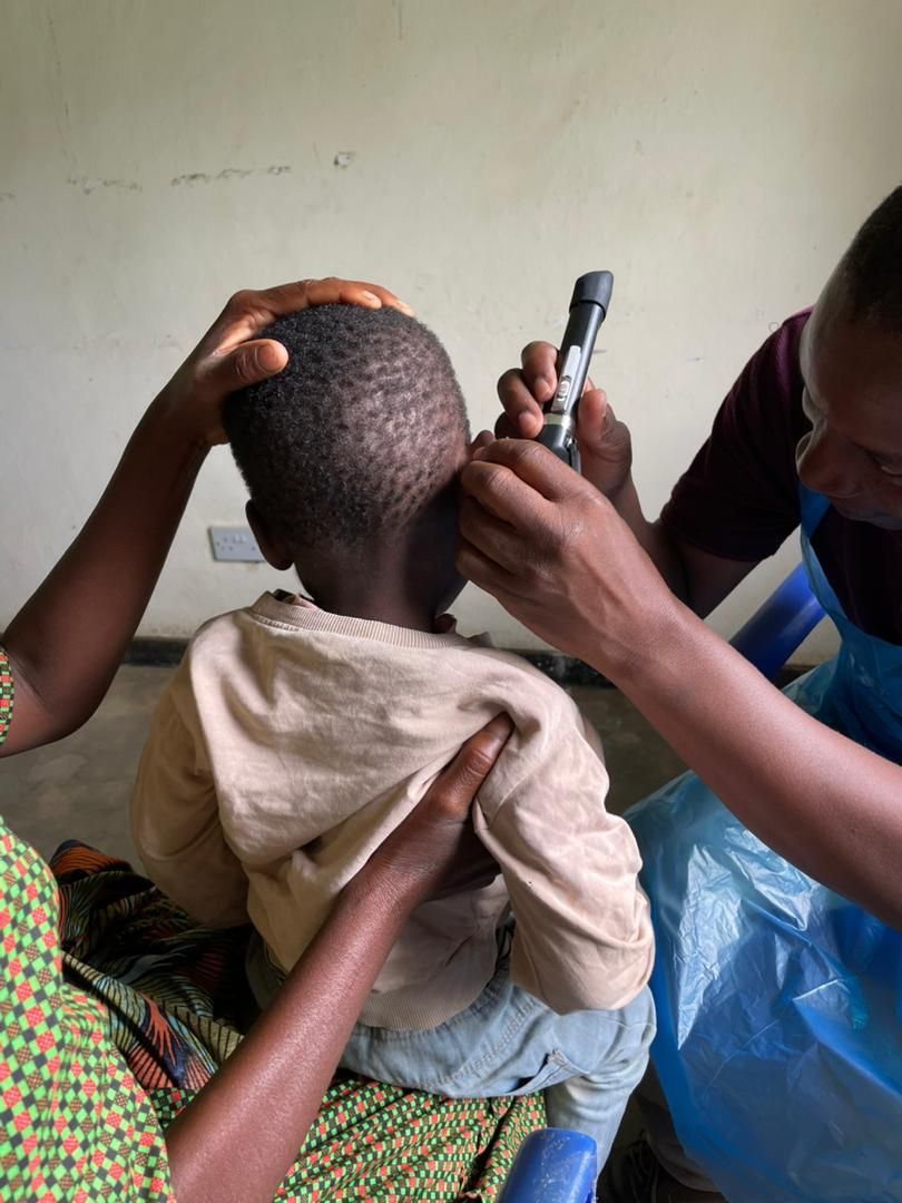 An african boy getting his ears checked by an african clinician