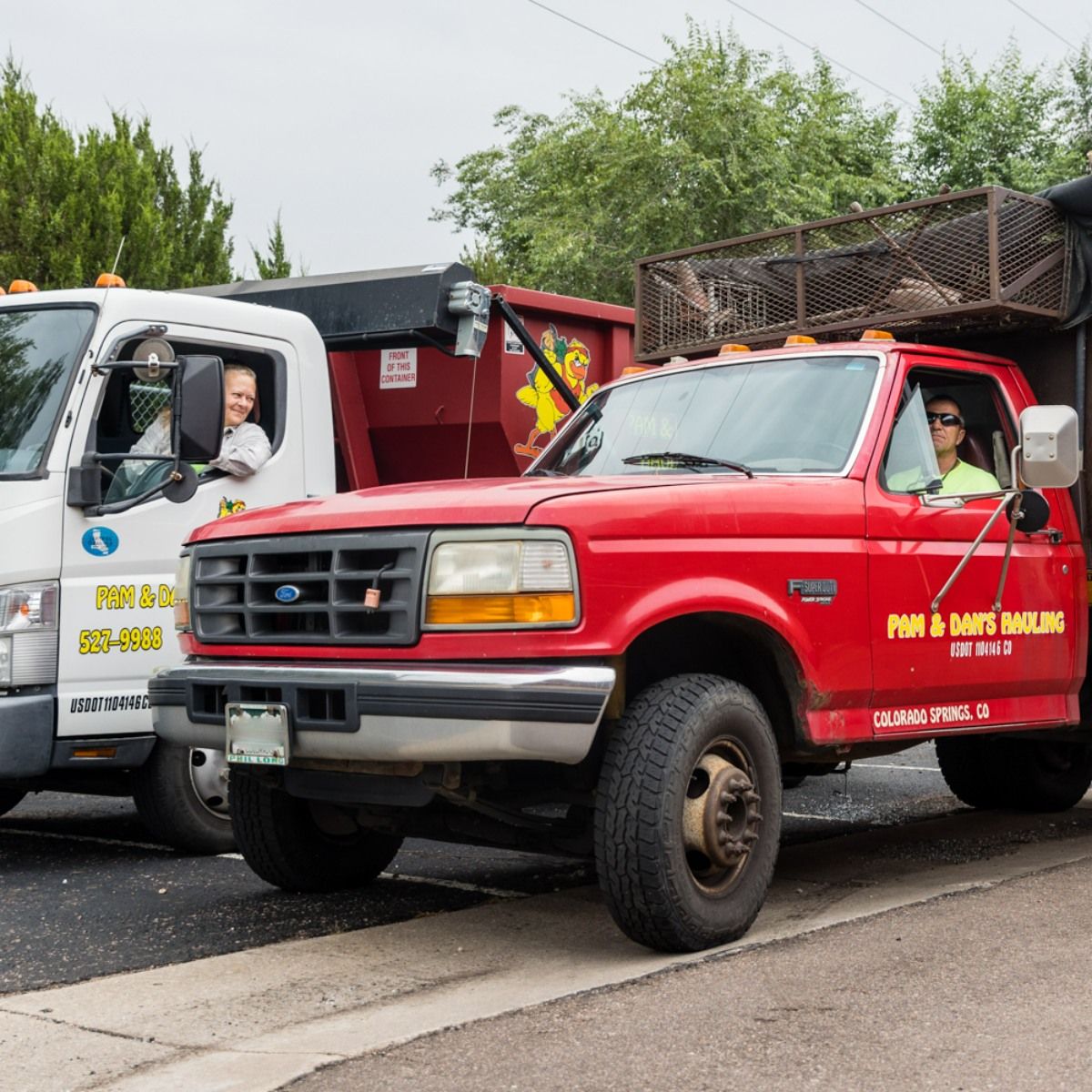 A red dumpster from pam and dan 's hauling