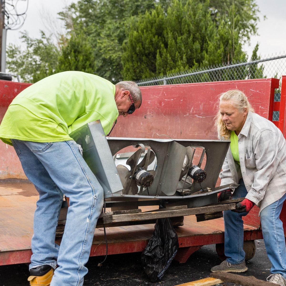 A man and a woman are working on a piece of equipment