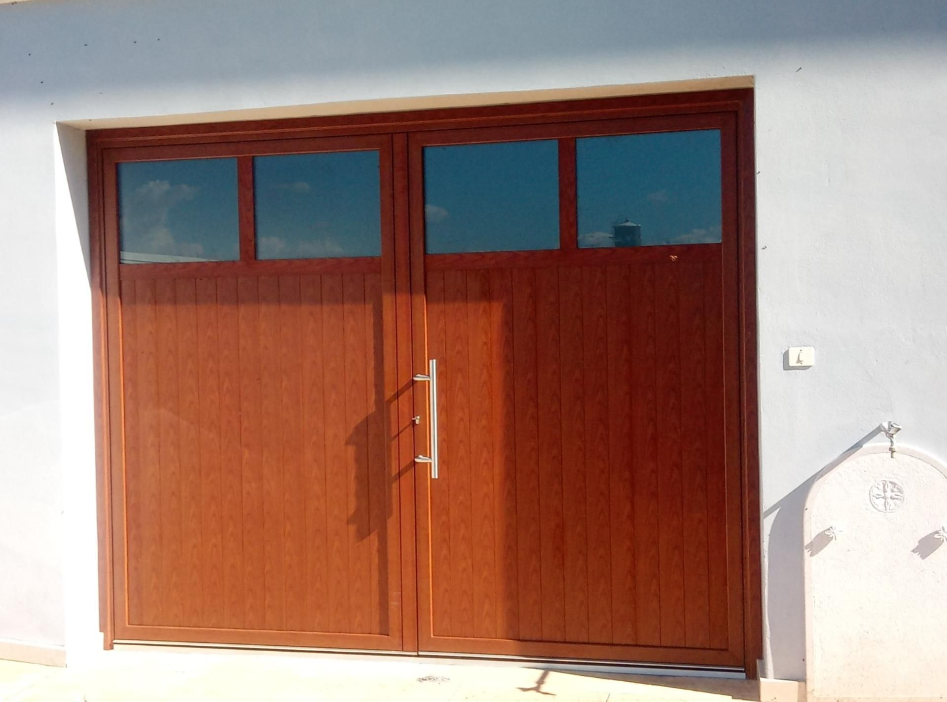 Una porta da garage in legno con maniglia in acciaio inox